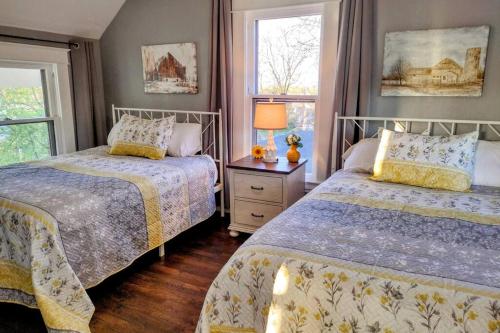 a bedroom with two beds and two windows at 1908 Modern Farmhouse on large private treed lot in Shawnee