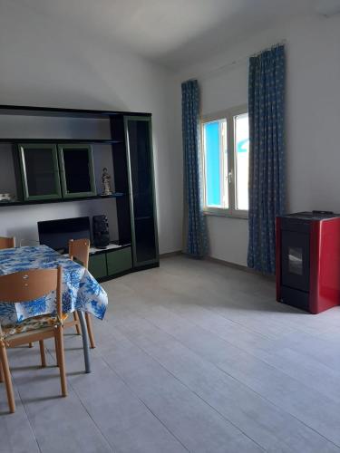 a living room with a table and chairs and windows at ARC BLEu in Siniscola