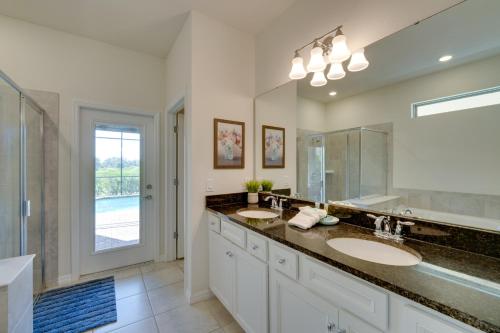 a bathroom with two sinks and a large mirror at Less Than 10 Mi to Disney Prime Resort Villa with Pool in Davenport