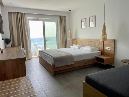 a bedroom with a bed and a view of the ocean at SunBeam in Kardamaina