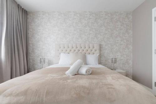 ein weißes Schlafzimmer mit einem großen Bett mit weißen Kissen in der Unterkunft Lovely En-suite Flat with Balcony and Parking. in London