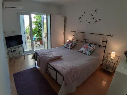 1 dormitorio con 1 cama grande y TV en Villa Tania, en Hvar