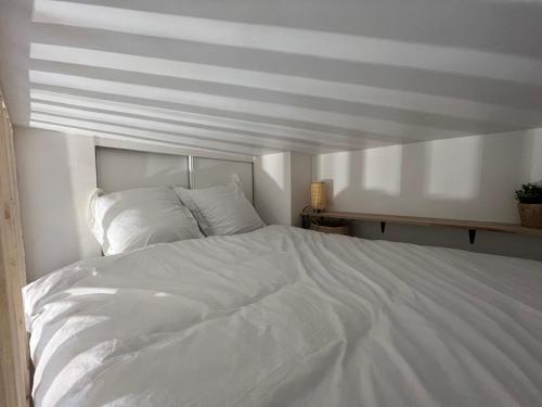 ein großes weißes Bett in einem weißen Schlafzimmer in der Unterkunft Le Nid douillet - HyperCentre - à 2 Pas de la Gare in Toulouse