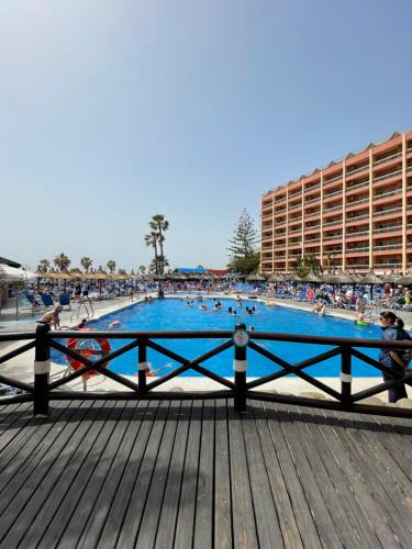 a large swimming pool on a pier with people in it at Sunset Beach Benalmadena in Benalmádena