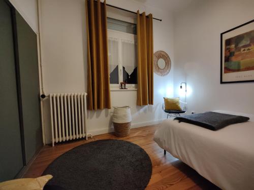 a bedroom with a bed and a window and a rug at L'appart du Canal in Carcassonne