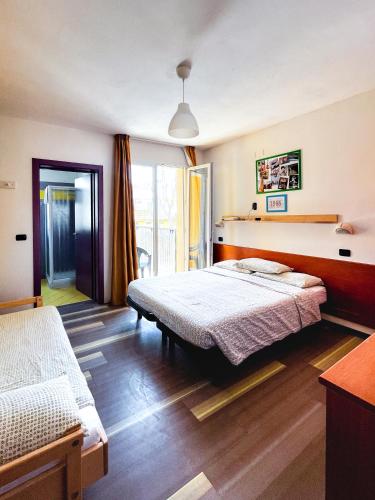 a bedroom with two beds and a window at Hotel Morfeo - Fun Hotel - NO FAMILY in Rimini