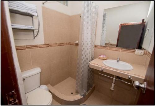 a bathroom with a toilet and a sink and a mirror at Nuevo Bamboo in Piura