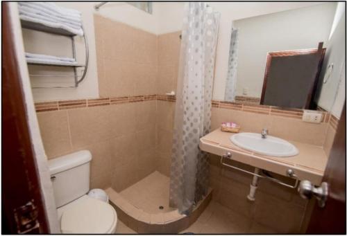 een badkamer met een toilet, een wastafel en een spiegel bij Nuevo Bamboo in Piura