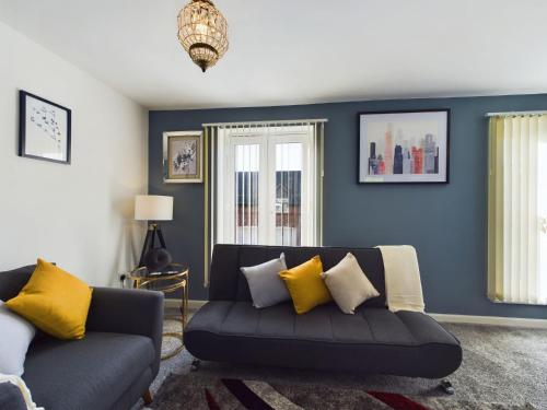 a living room with a couch with yellow pillows at 247 Serviced Accommodation in Stafford- 3BR Townhouse in Stafford