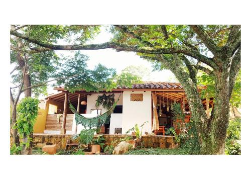 ein Haus mit einer Hängematte davor in der Unterkunft CALA Guane Barichara in Guarne