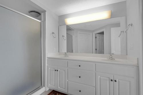 un bagno bianco con due lavandini e un grande specchio di Treasure Island 0207 a Panama City Beach