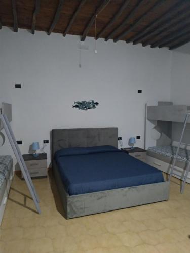 Un dormitorio con una cama con sábanas azules y una escalera en perla spiaggia, en Leni