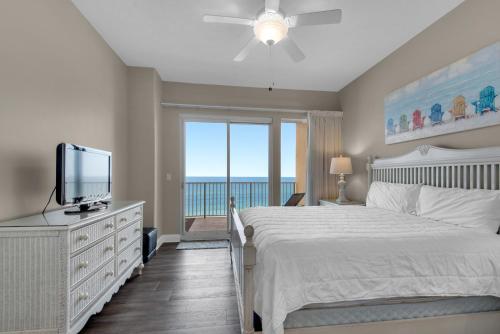 a bedroom with a bed and a tv and a window at Treasure Island 0403 in Panama City Beach