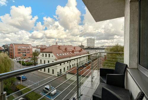 a balcony with chairs and a view of a city at Qubus Hotel Bydgoszcz in Bydgoszcz