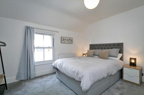 a white bedroom with a bed and a window at Finest Retreats - Brook View in Colwyn Bay