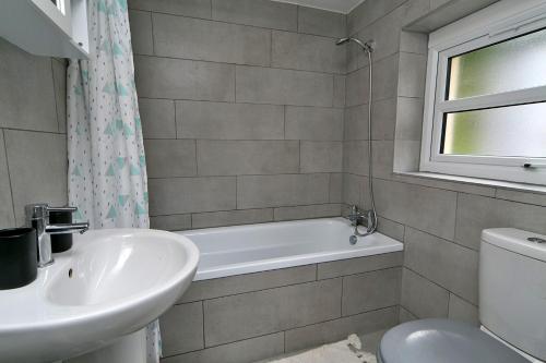 a bathroom with a sink and a tub and a toilet at Finest Retreats - Brook View in Colwyn Bay