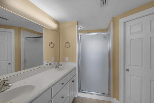 La salle de bains est pourvue d'une douche et d'un lavabo blanc. dans l'établissement Treasure Island 0202, à Panama City Beach