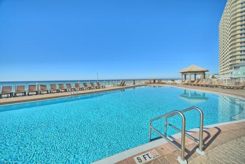 a large swimming pool with the beach in the background at Treasure Island 2202 in Panama City Beach