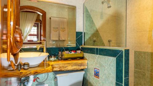 uma casa de banho com um lavatório, um espelho e uma banheira em Monyoli Hotel & Boutique em Acapulco