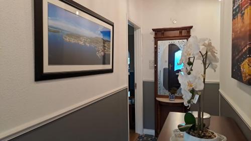 un pasillo con una foto en la pared y un jarrón con flores en Pinebrook BnB En-suite 1 double bed, en Killybegs