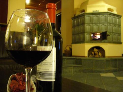 a glass of wine next to a bottle of wine at Rosenhof in Ebensee