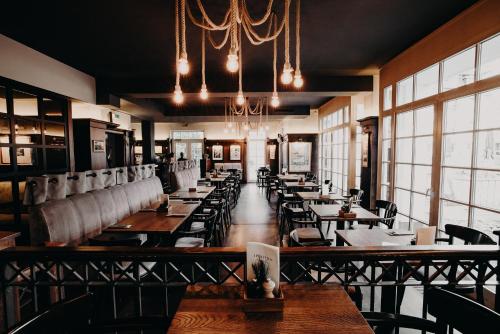 a restaurant with tables and chairs and a chandelier at Hotel Boje06 in Heringsdorf