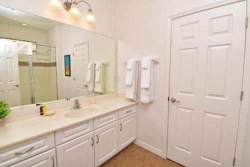 a white bathroom with a sink and a mirror at Rose End Villa G in Davenport