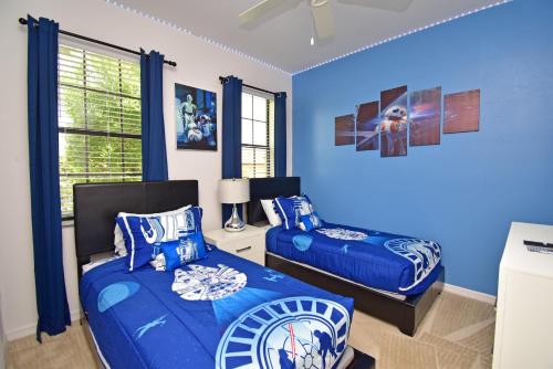 a bedroom with two beds and a blue wall at Rose End Villa G in Davenport