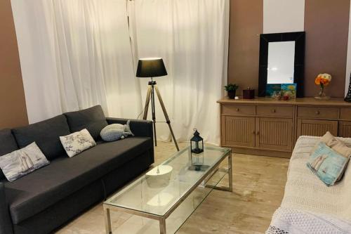sala de estar con sofá y mesa de cristal en Maison de vacances espagnole en bord de plage, en Miami Platja
