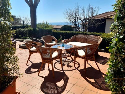 eine Terrasse mit einem Tisch und Stühlen auf einer Terrasse in der Unterkunft Dilly Home Holiday-Casa vacanze in Aci Castello