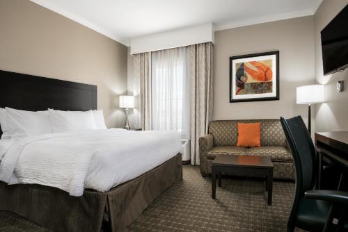 a hotel room with a bed and a couch at TownePlace Suites by Marriott Seguin in Seguin
