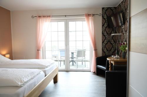 Schlafzimmer mit einem Bett und einem Fenster mit einem Tisch in der Unterkunft Gästehaus Knaup in Treis-Karden