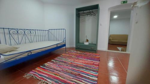 um quarto com uma cama e um tapete no chão em Casa dos Marias em Elvas