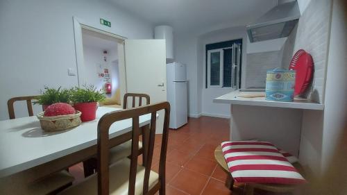 uma cozinha com uma mesa e cadeiras numa cozinha em Casa dos Marias em Elvas