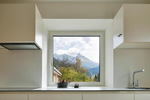 a kitchen window with a view of a mountain at Casa Lies - Apartments in Nova Ponente