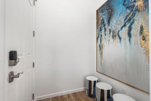 a bathroom with a large painting on the wall and two stools at @ Marbella Lane - 4BR w/ Splendid MT + Ocean Views in Waianae