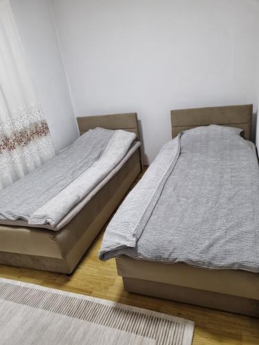 um quarto com 2 camas e uma janela em Apartman- Sarajevo em Sarajevo