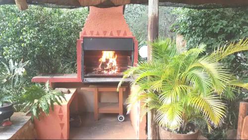 un horno de ladrillo con fuego en un jardín en Canyon guest villa en Hoedspruit