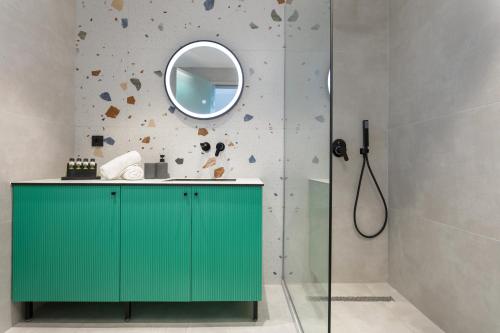 a bathroom with a green cabinet and a mirror at Akrogiali Luxury View in Laganas