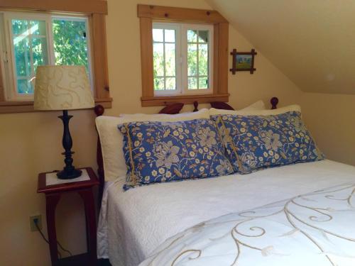 a bedroom with a bed and a lamp and windows at Bond Ranch Retreat in Sequim