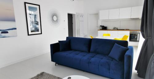 a blue couch in a living room with a kitchen at OXYGEN NEPTUN BY BOUTIQUE C5 in Neptun