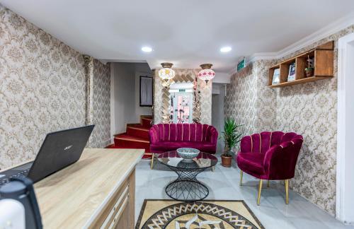 una sala de estar con 2 sillas rojas y una mesa. en OttomanZade en Estambul