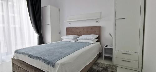 a bedroom with a bed with white walls and a window at OXYGEN NEPTUN BY BOUTIQUE C5 in Neptun