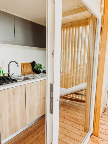 a kitchen with wooden cabinets and a view of a balcony at Diamond Coast Mobile Home in Drage