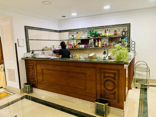 a woman standing at the counter of a restaurant at Hotel Principe Di Piemonte in Rome