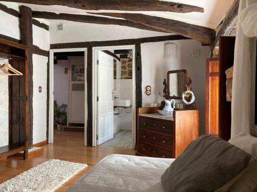 um quarto com uma cama, uma cómoda e um espelho em Casa parejas La casa de Quintanilla 1 em Quintanilla las Torres