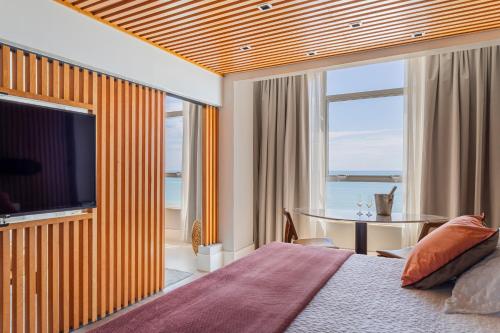 a hotel room with a bed and a television at Praiano Hotel in Fortaleza