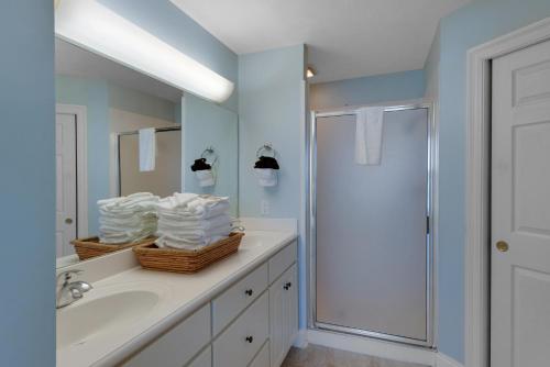 ein Badezimmer mit einem Waschbecken und einer Dusche mit Handtüchern in der Unterkunft Treasure Island 0408 in Panama City Beach