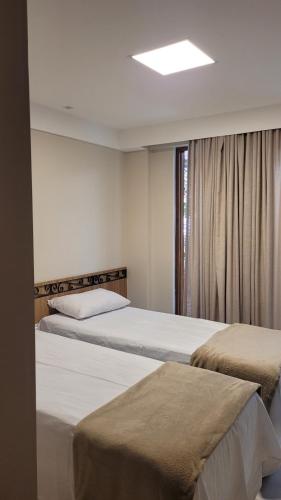 um quarto com 2 camas e uma janela em Villa Andorinha -Apto01 em Mucugê