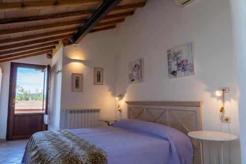 1 dormitorio con cama, mesa y ventana en MAREMMA TOSCANA [PISCINA & IDROMASSAGGIO] en Grosseto